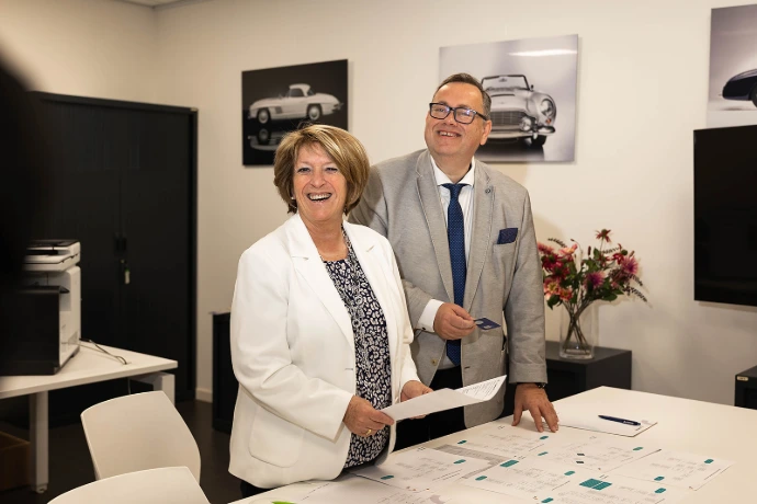 Foto van een lachende General Manager Katty en sales collega Michel.